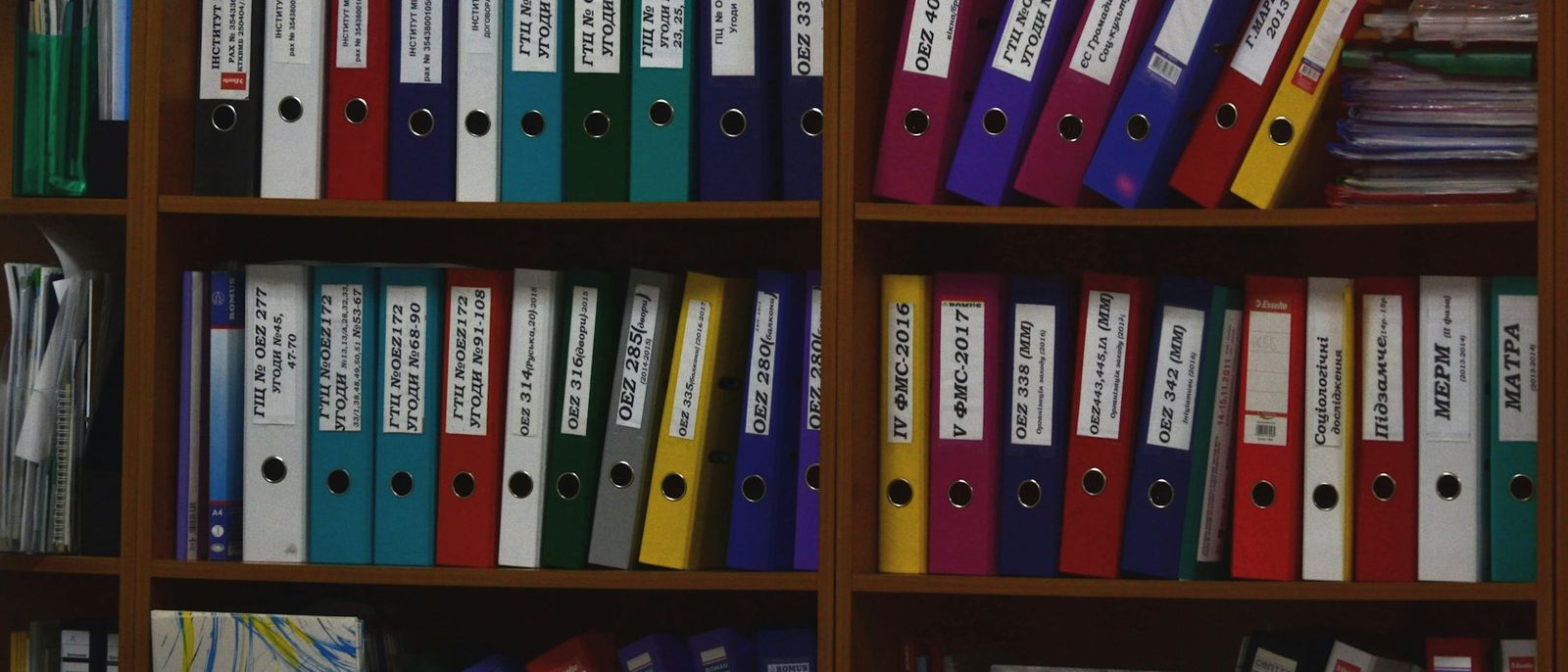 Rows of labelled ring binders on a shelf